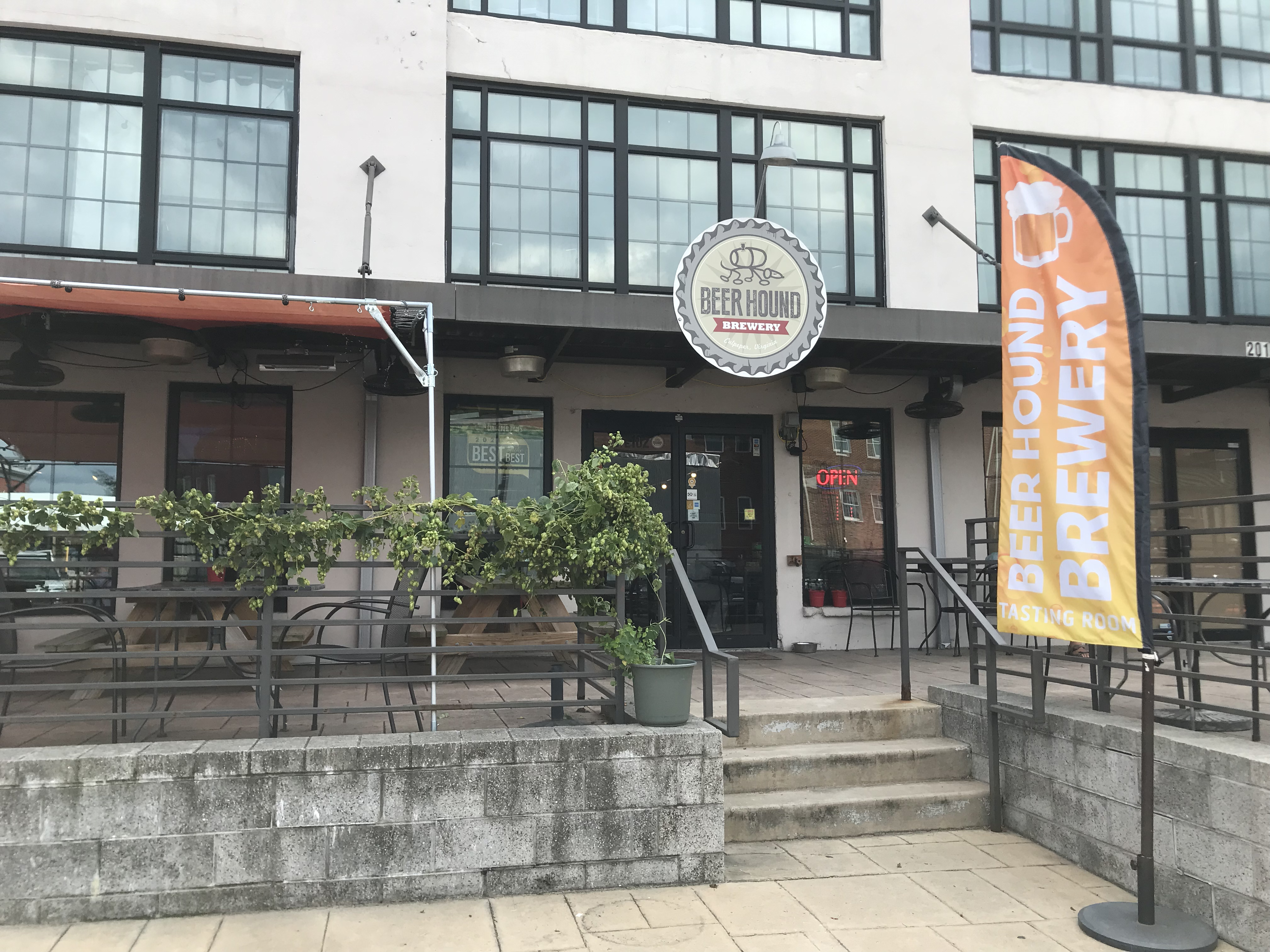 Image of Beer Hound Brewery's patio with hop vines decorating the patio railing.